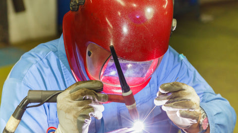 TIG Welding with red helmet gloves and torch